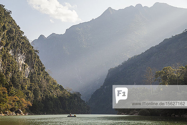 Robert Hahn betrachtet die über ihm aufragenden Karstfelsen am Nam Ou Fluss in der Nähe von Muang Ngoi  Laos.