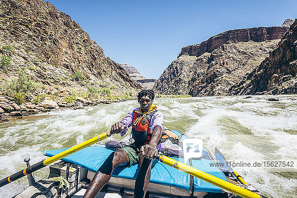 Ein Mann rudert ein Floß durch eine Stromschnelle auf dem Colorado River  Grand Canyon National Park  Arizona  USA