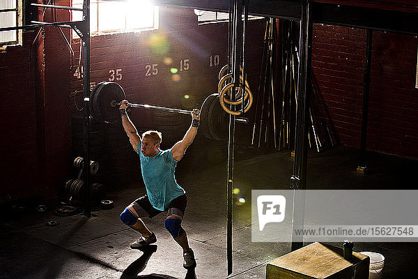 A crossfit athlete doing overhead squats at a gym in San Diego  CA.