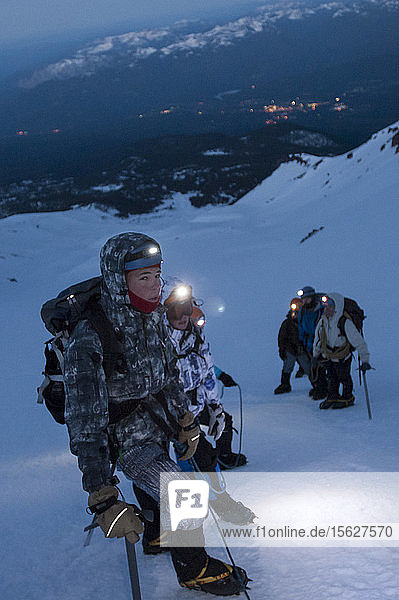 Jungen im Alter von 13 bis 17 Jahren von der Venturing Crew 191 aus Glendora  Kalifornien  setzen ein Jahr Training in die Praxis um  als sie versuchen  den Gipfel des Mount Shasta über die Avalanche Gulch-Route im Shasta Trinity National Forest in Nordkalifornien zu erreichen. Der Mount Shasta ist ein massiver  vergletscherter Vulkan und mit 14.179 Fuß der zweithöchste Gipfel in der Cascade Range und der fünfthöchste in Kalifornien; er ist mit keinem anderen Gipfel verbunden und erhebt sich abrupt 10.000 Fuß über das umliegende Gelände. Die Pfadfinder der Venturing Crew 191 (Venturing Crews sind ein Zweig der Pfadfinder  der sich auf abenteuerliche Aktivitäten konzentriert) hatten sich ein Jahr lang auf die Besteigung des Mount Shasta vorbereitet. Dies war ihre erste Erfahrung mit dem Klettern in steilem Schnee  und sie wurden bei der Besteigung von Führern der SWS Mountain Guides unterstützt. Frühmorgens vor Sonnenaufgang klettern Josh Kolbach und Jeremy Kolbach mit Steigeisen und Eispickeln als Seilschaft  darunter ein weiteres Team  bestehend aus den Bergführern Casey Hurden (vorne)  Morgan Howlett  Dillon Travis und Mark Howlett  im steilsten Teil der Avalanche Gulch auf etwa 11.500 Fuß  auf dem Weg zum Gipfel des Mount Shasta  Shasta Trinity National Forest  Kalifornien. Die Crew begann ihren Aufstieg sehr früh  um sicherzustellen  dass sie den Gipfel noch vor dem Mittag erreichten und die Lichter der Stadt Mount Shasta im Tal darunter zu sehen sind.