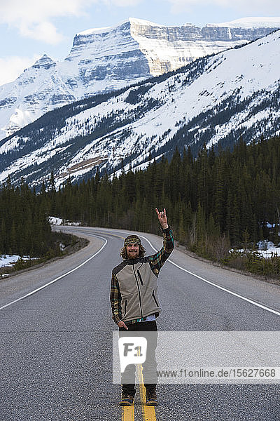 Snowboarder  der in der Mitte der Straße in Kanada steht