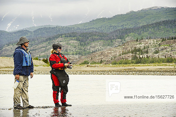 Two Rafters Fly Fishing In Alsek River Of Canada