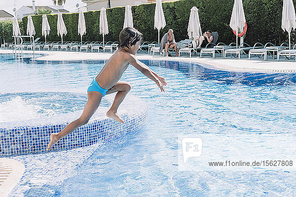 A kid jumps in a hotel pool  Mallorca  Balearic Islands  Spain