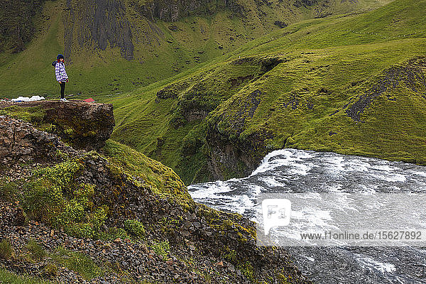 Tourists visitï¾ Skogafoss  one of the most iconic waterfalls in Iceland. Located near Highway Oneï¾ (alsoï¾ known as the Ringï¾ Road)  the waterfall cascades 60 meters and has trails that allow visitors to walk up right to the bottom and top of the falls. The waterfall is located on the Skoga River  which travels through the highlands of Iceland before it reaches the Atlantic Ocean.ï¾ 