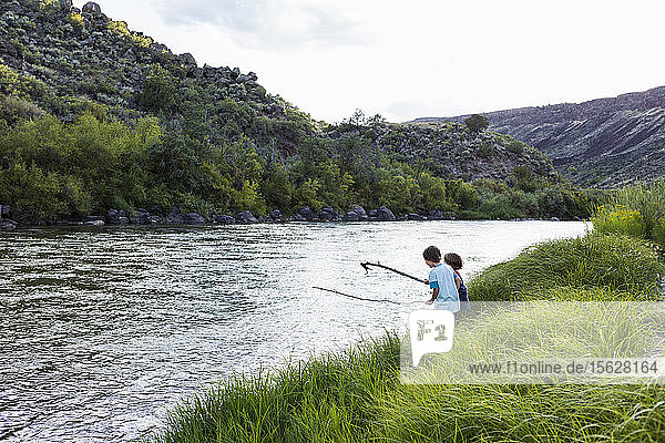 2 boys playing at the edge of the Rio Grande River  Pilar  NM.
