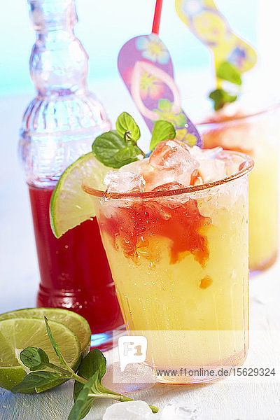 Sommerlicher Cocktail mit Pfirsichlikör  Orangensaft  Limette und Erdbeersirup