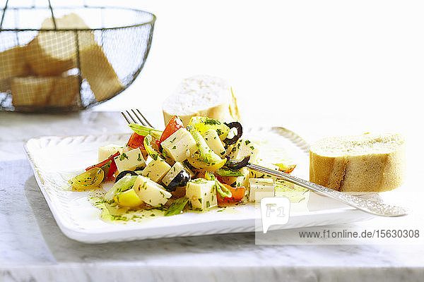 Marinierte Goudawürfel mit Kirschtomaten  Oliven  Zwiebel  Kräutern und Baguette