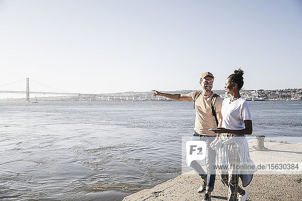 Junges Paar beim Spaziergang am Pier am Wasser  Lissabon  Portugal