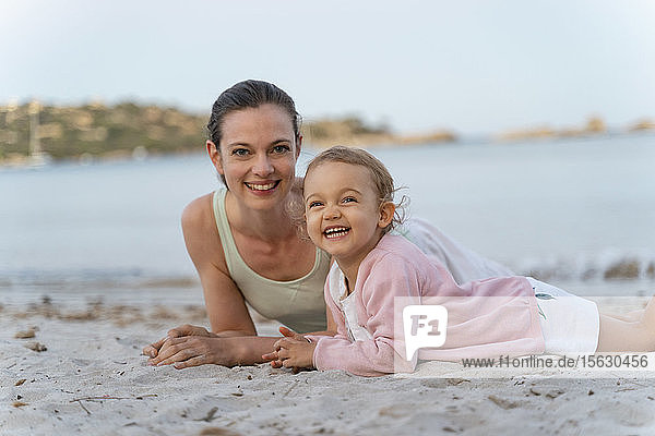 Porträt einer glücklichen Mutter mit Tochter am Strand