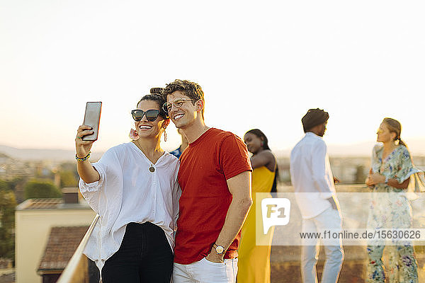 Junge Frau und Mann beim abendlichen Selfie auf einer Party