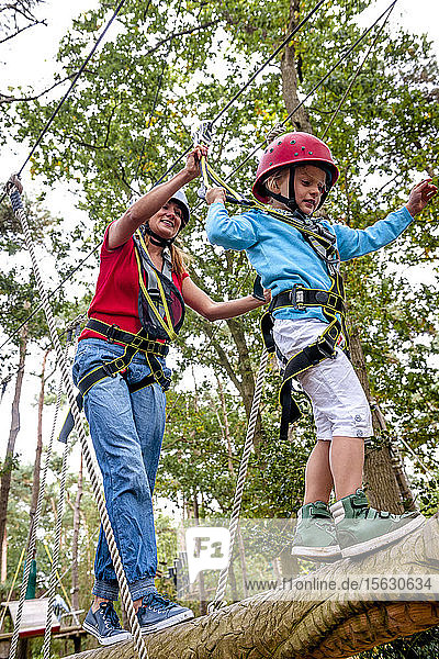 Mother and daughter on a high rope course in forest