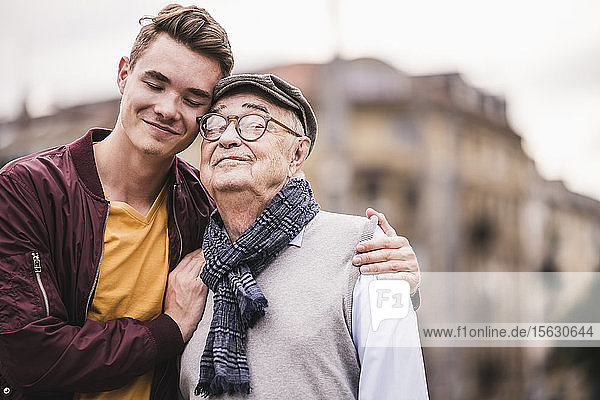 Porträt eines glücklichen älteren Mannes Kopf an Kopf mit seinem erwachsenen Enkel