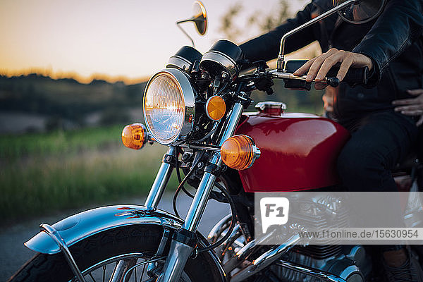 Schnappschuss eines Paares auf einem Oldtimer-Motorrad bei Sonnenuntergang