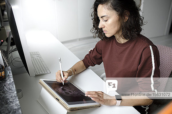 Weibliche Webdesignerin benutzt Tablet zu Hause