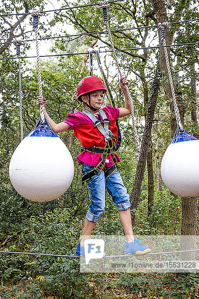 Girl on a high rope course in forest