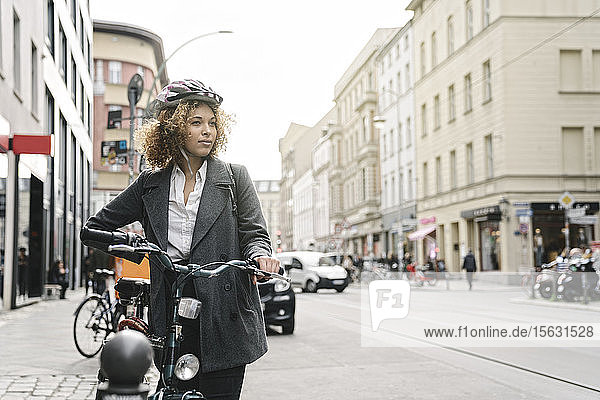 Frau mit Fahrrad in der Stadt  Berlin  Deutschland