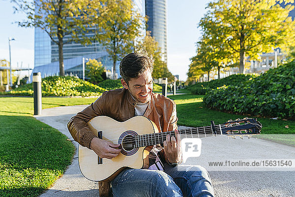 Man playing guitar in an urban park  Madrid  Spain