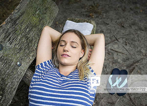Frau entspannt sich auf einer Holzbank