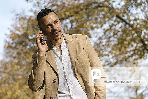 Porträt eines Geschäftsmannes am Telefon im Herbst