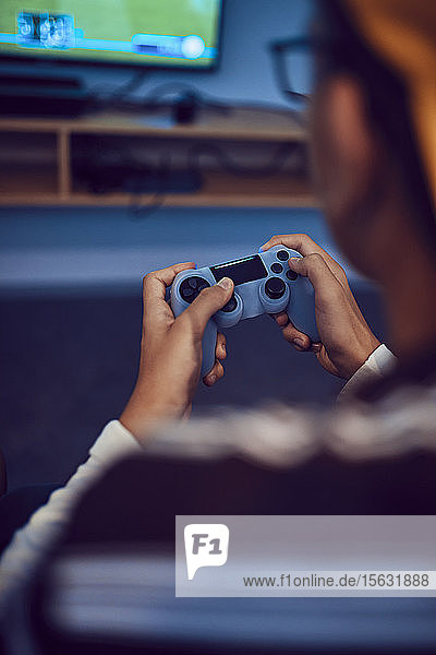 Nahaufnahme eines Teenagers der ein Videospiel in einer Spielhalle spielt