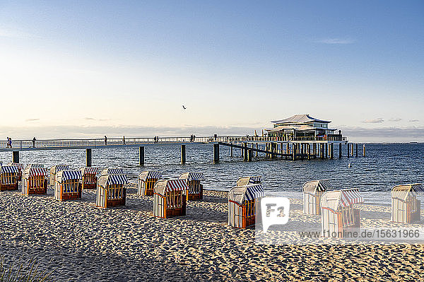 Deutschland  Schleswig-Holstein  Timmendorf  Strandkorb Strandkörbe am sandigen Küstenstrand mit Pier im Hintergrund