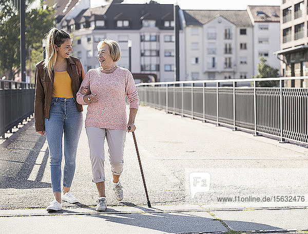 Granddaughter and her grandmother walking on footbridge