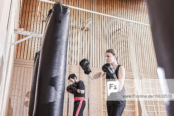 Trainerin und Boxerin beim Boxsacktraining in der Sporthalle