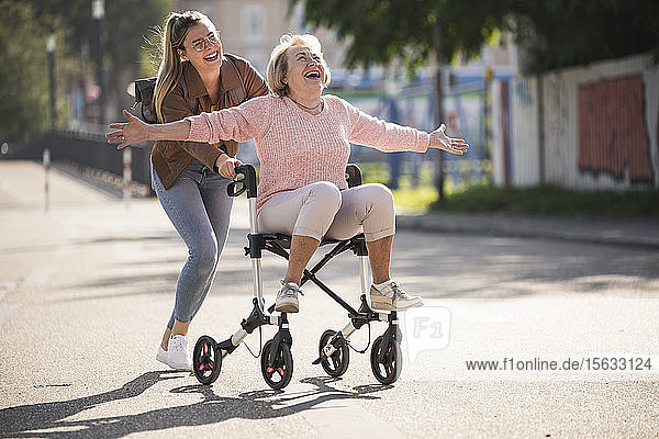 Granddaughter and her grandmother having fun with wheeled walker