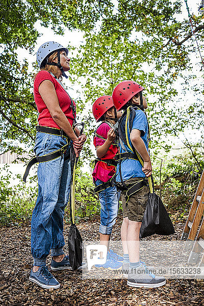 Family preparing for a rope course in forest