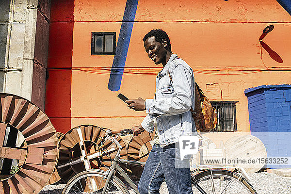 Entspannte junge Leute pendeln in der Stadt mit dem Hos-Fahrrad  mit Smartphone