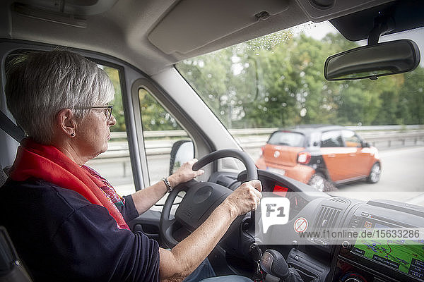 Senior woman driving camper van