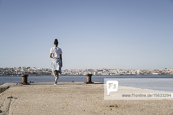 Junge Frau beim Spaziergang am Pier am Wasser  Lissabon  Portugal