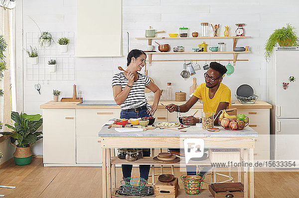 Multiethnisches Paar frühstückt gemeinsam in der Küche
