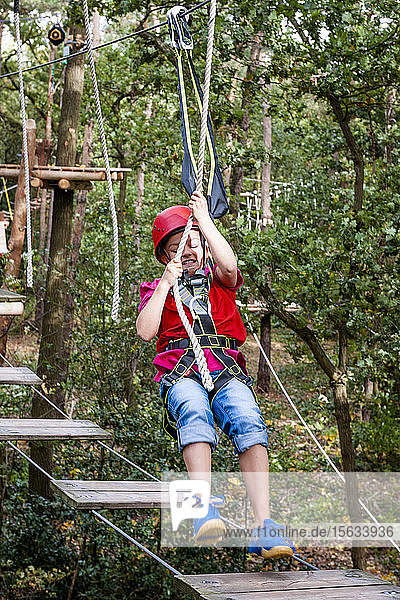 Girl on a high rope course in forest