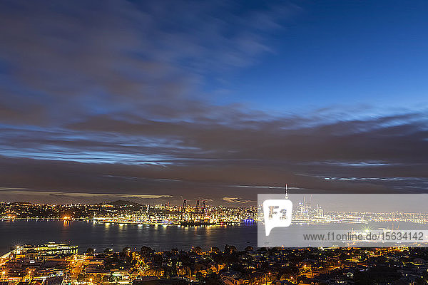 Beleuchtete moderne Gebäude am Meer vor bewölktem Himmel in der Stadt Auckland  Neuseeland