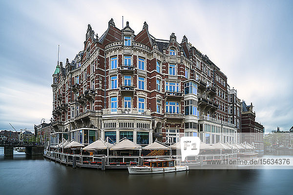 Niederlande  Amsterdam  Vordächer von Cafés  die Gebäude am Wasser umgeben