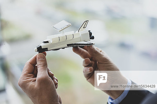 Nahaufnahme eines Geschäftsmannes mit einem Space-Shuttle-Modell