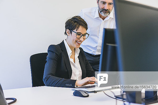 Businessman and employee at desk in office