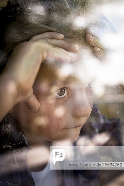 Portrait of girl looking through window
