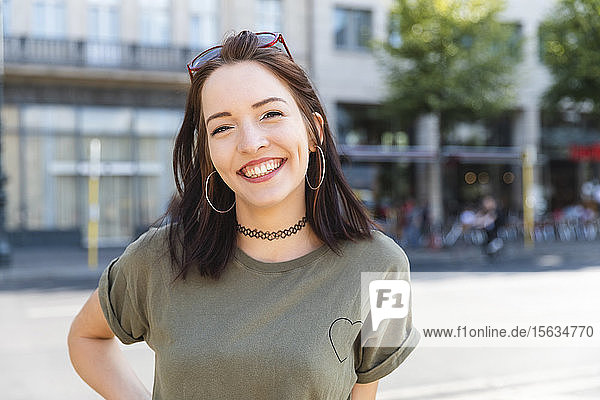 Porträt einer lachenden jungen Frau in der Stadt