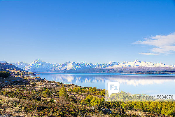 Neuseeland  Südinsel  Landschaftliche Ansicht des Ufers des Pukaki-Sees mit schneebedeckten Bergen im Hintergrund