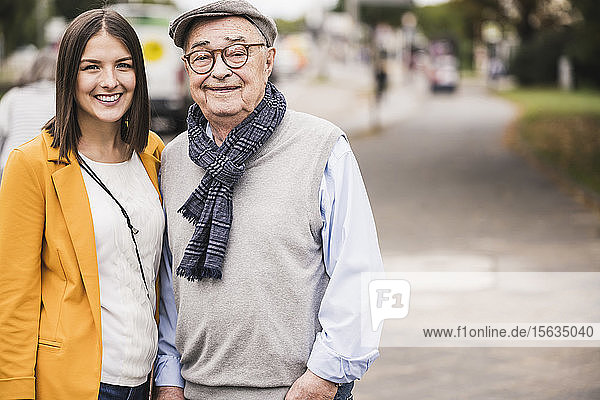Porträt eines älteren Mannes Seite an Seite mit seiner erwachsenen Enkelin