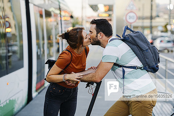 Küssendes Paar an der Straßenbahnhaltestelle