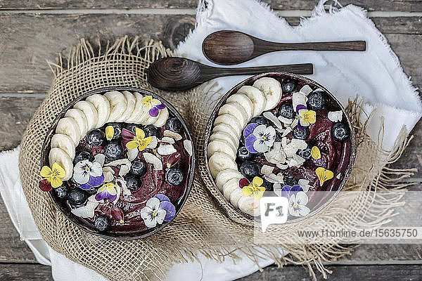 Direkt über Eiscreme mit Früchten und Blumen garniert in Schalen auf dem Tisch serviert