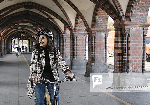 Happy woman riding bicycle in the city  Berlin  Germany