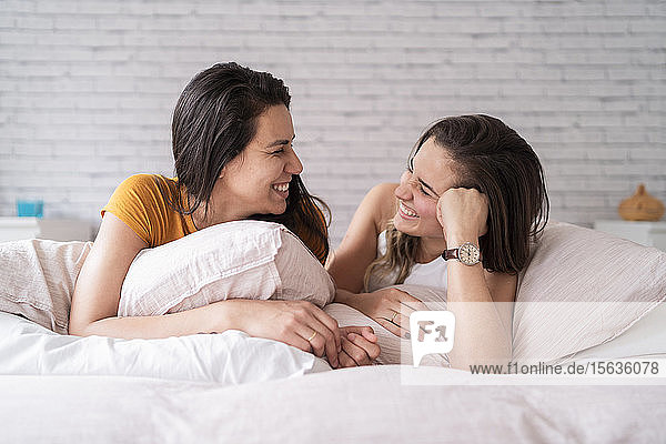 Happy lesbian couple lying in bed
