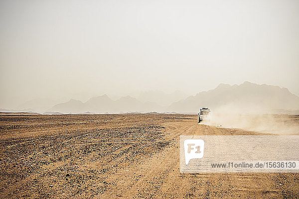 Geländewagen bewegt sich in trockener Landschaft vor klarem Himmel  Suez  Ägypten