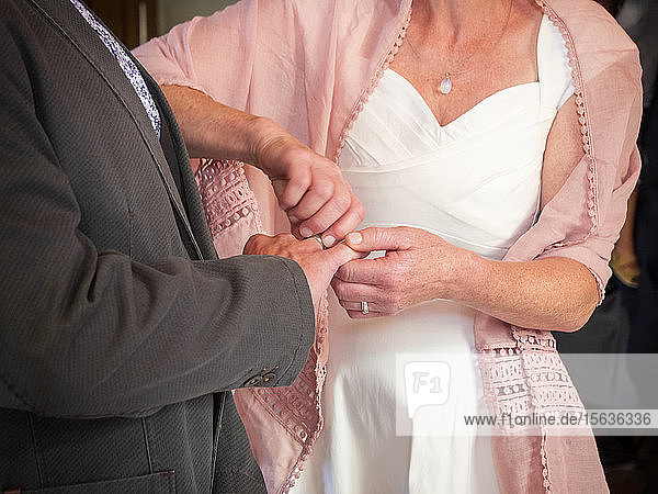 Braut steckt dem Bräutigam den Ehering an den Finger