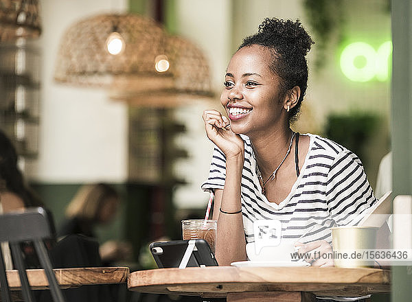Porträt einer glücklichen jungen Frau in einem Cafe
