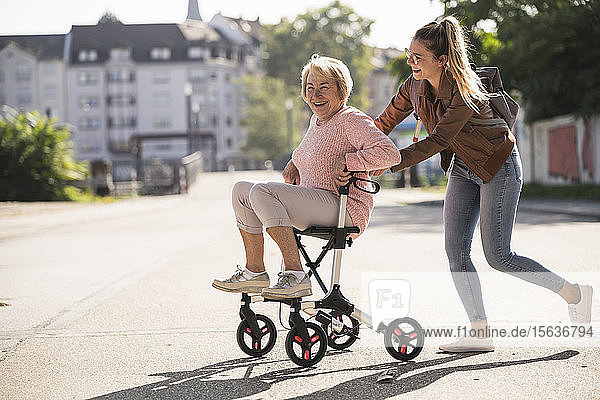Enkelin und ihre Großmutter amüsieren sich mit Rollator